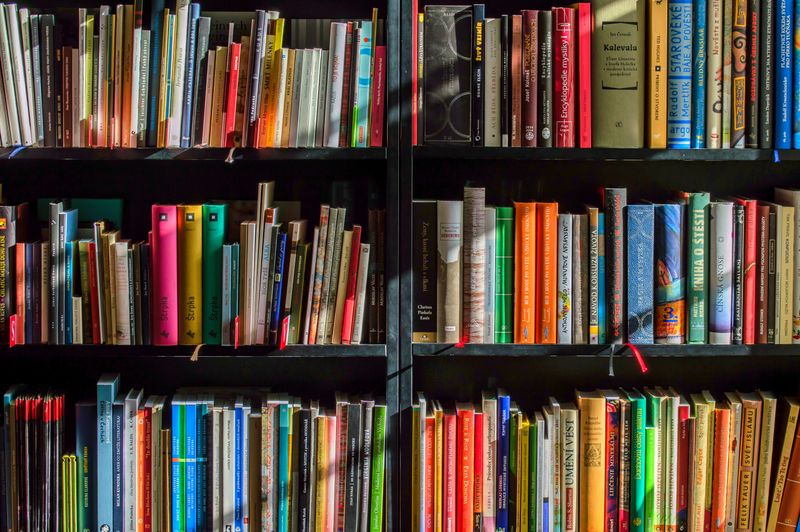 Libros apilados junto a una libreta con notas manuscritas sobre la mesa